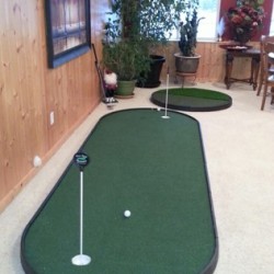 small indoor putting green next to chipping pad